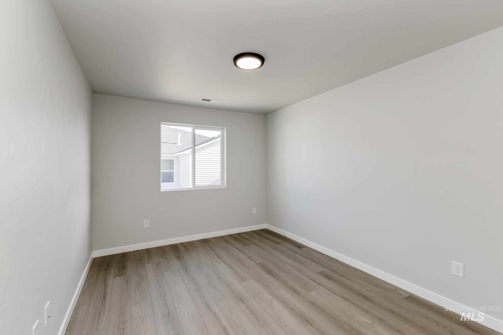 1804 West Unforgettable Street Meridian, ID 83642 - Photo 9 of 18 Spare room featuring light wood-type flooring and baseboards