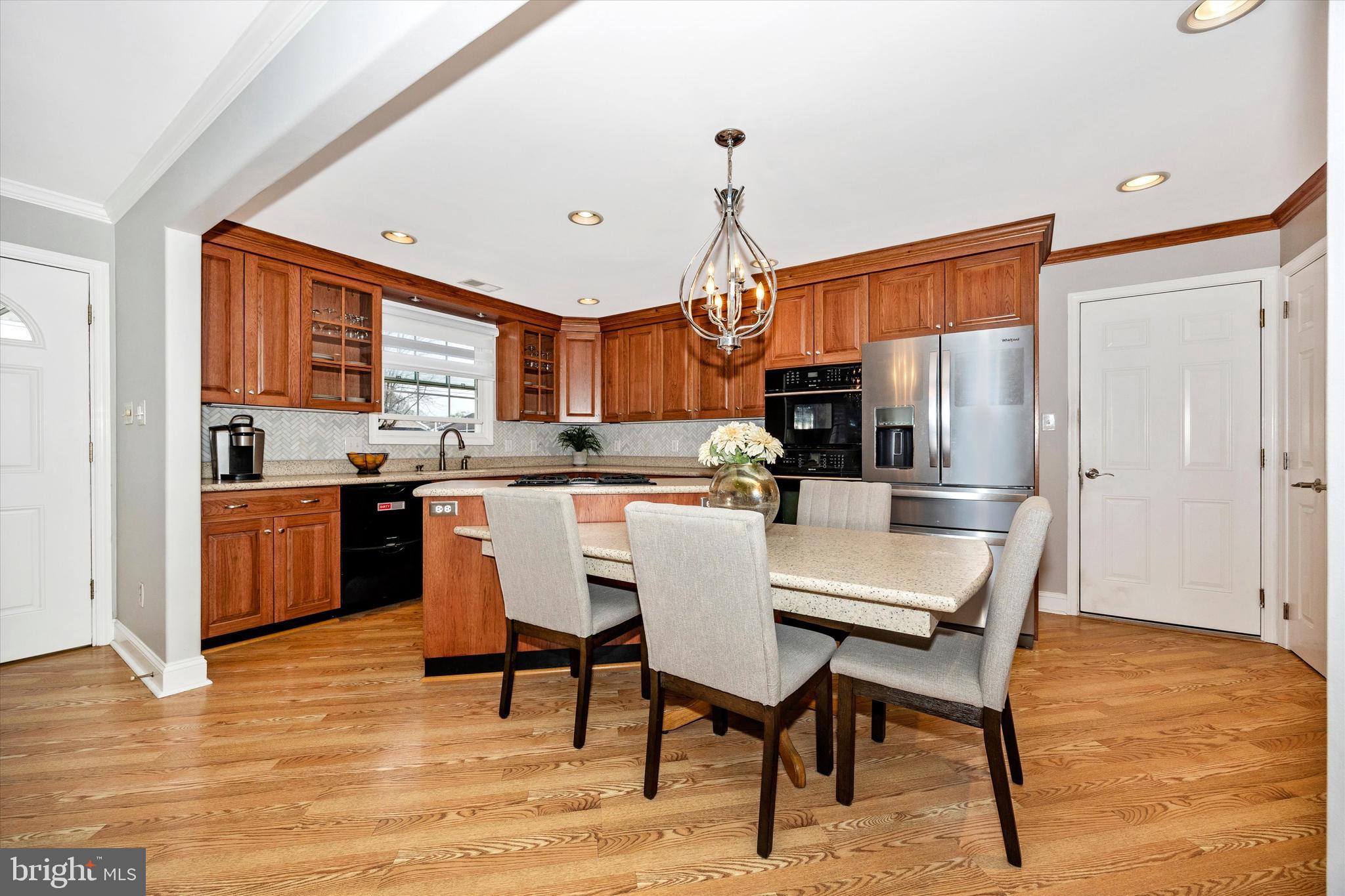 307 Redwood Avenue Frederick, MD 21701 - Photo 7 of 23 a kitchen with stainless steel appliances kitchen island granite countertop a table chairs sink and cabinets