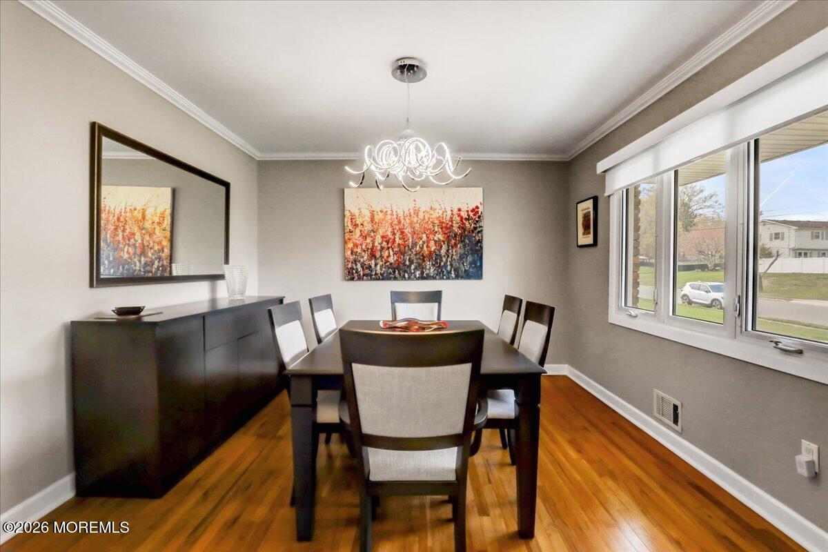 21 Prince William Road Morganville, NJ 07751 - Photo 14 of 39 a view of a dining room with furniture a chandelier and wooden floor