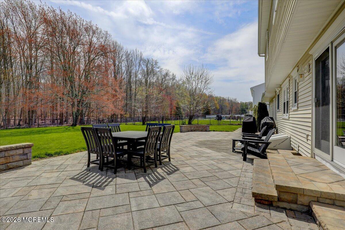 21 Prince William Road Morganville, NJ 07751 - Photo 28 of 39 a view of a patio with table and chairs potted plants and a large tree