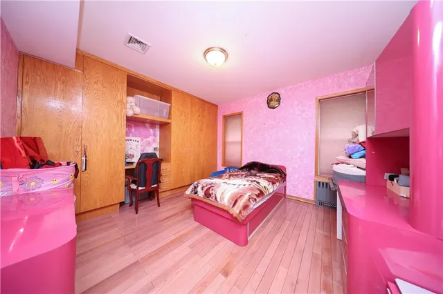 a spacious bedroom with a bed and a dresser