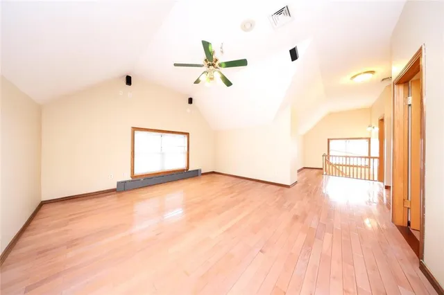 a view of a room with wooden floor and a ceiling fan