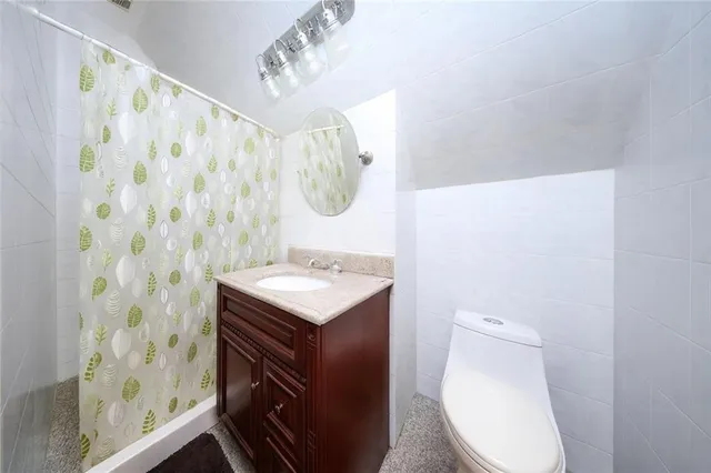 a bathroom with a sink a toilet and shower curtain