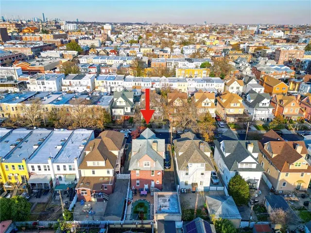 an aerial view of residential houses with outdoor space and swimming pool