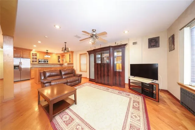 a living room with furniture a flat screen tv and kitchen view