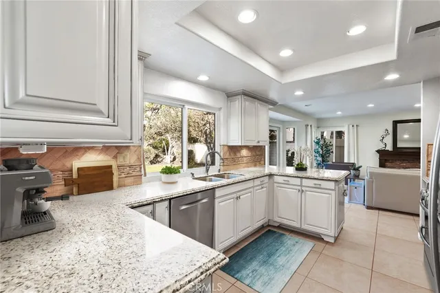 a kitchen with stainless steel appliances granite countertop a sink and dishwasher a stove top oven with wooden floor