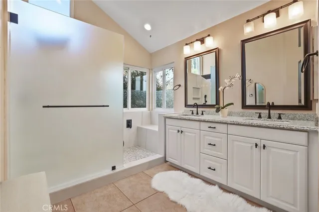 a bathroom with a double vanity sink and mirror with shower