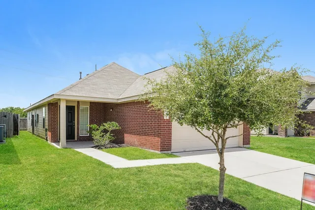 a front view of a house with a yard and potted plants
