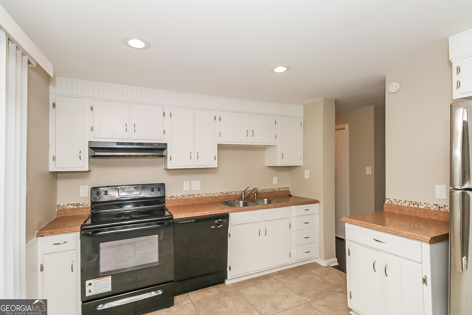 3100 Forestside Court Atlanta, GA 30349 - Photo 6 of 17 a kitchen with stainless steel appliances white cabinets and a stove top oven