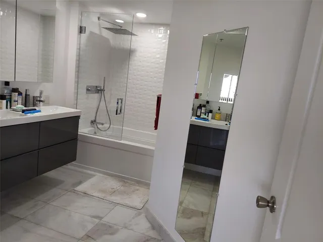 a bathroom with a bathtub sink and mirror