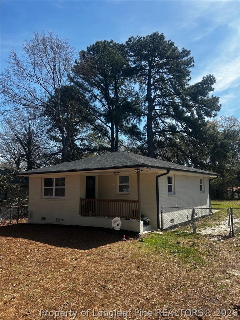 a view of a house with backyard and trees