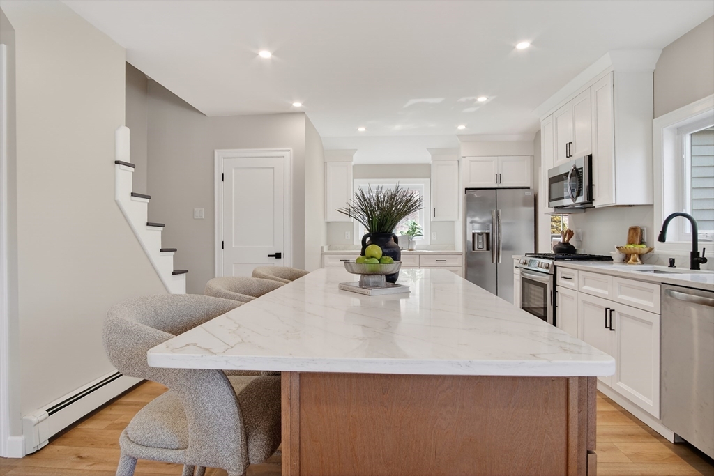 5 Springdale Avenue Saugus, MA 01906 - Photo 6 of 26 a kitchen with stainless steel appliances a kitchen island a stove a table and chairs