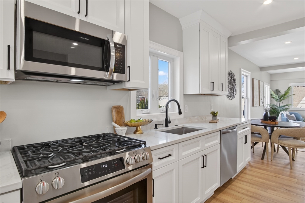 5 Springdale Avenue Saugus, MA 01906 - Photo 8 of 26 a kitchen with stainless steel appliances granite countertop a stove a microwave a sink and cabinets