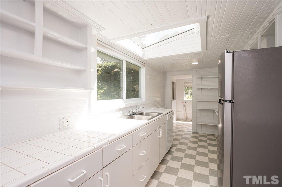 511 Frank Street Raleigh, NC 27604 - Photo 10 of 26 a kitchen with a sink a stove a refrigerator and a cabinets