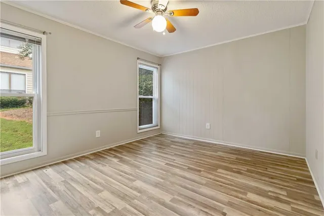 a view of an empty room with window and wooden floor
