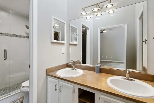 a bathroom with a sink double vanity granite toilet and shower