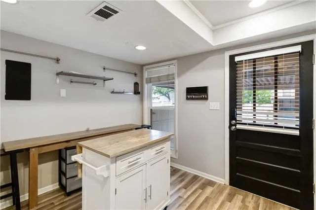 a view of kitchen with stainless steel appliances cabinets and a table
