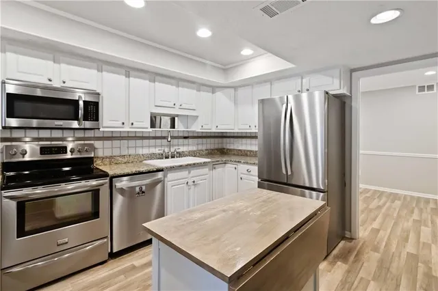 a kitchen with kitchen island granite countertop a stove sink and microwave