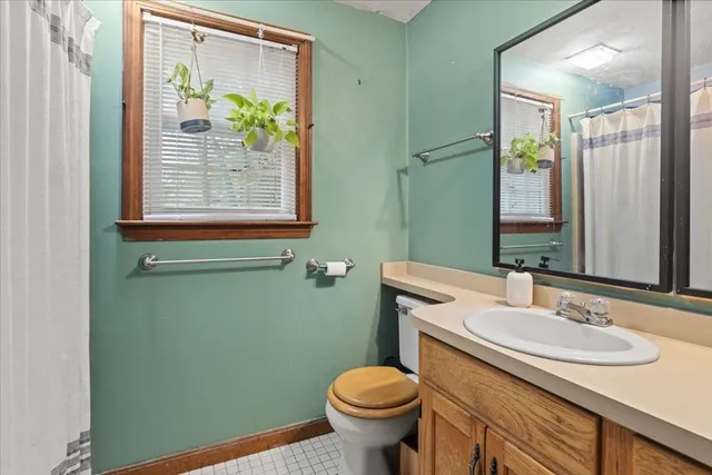 a bathroom with a granite countertop toilet sink and mirror