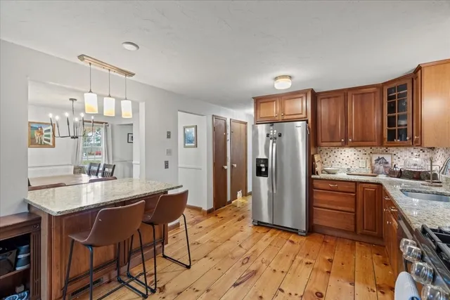 a kitchen with stainless steel appliances granite countertop a refrigerator and a stove top oven