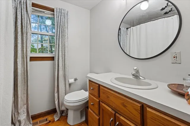 a bathroom with a toilet a sink and mirror