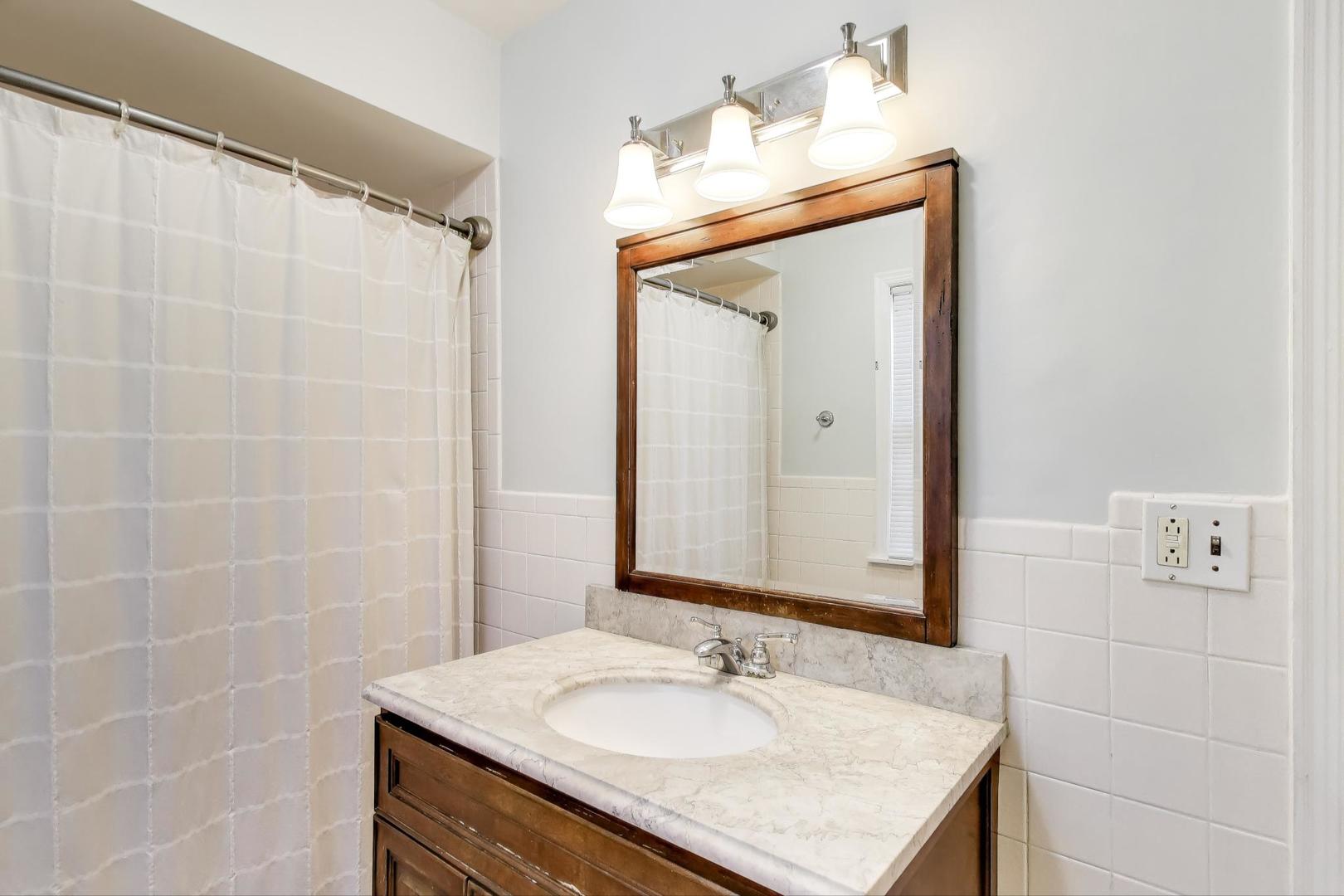 3131 Central Street Evanston, IL 60201 - Photo 17 of 28 a bathroom with a sink vanity granite and a mirror