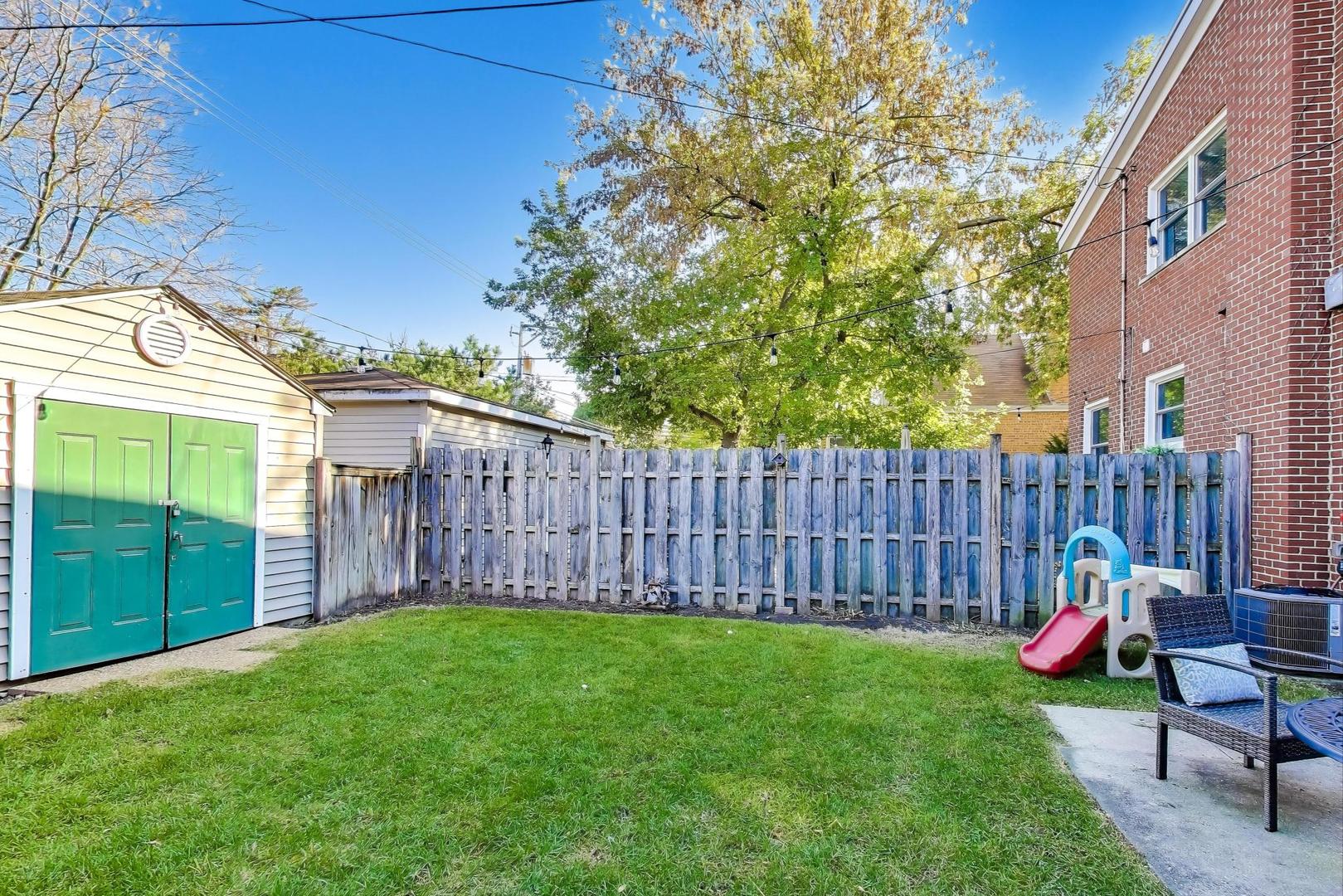 3131 Central Street Evanston, IL 60201 - Photo 25 of 28 a view of a backyard with a swing and wooden fence