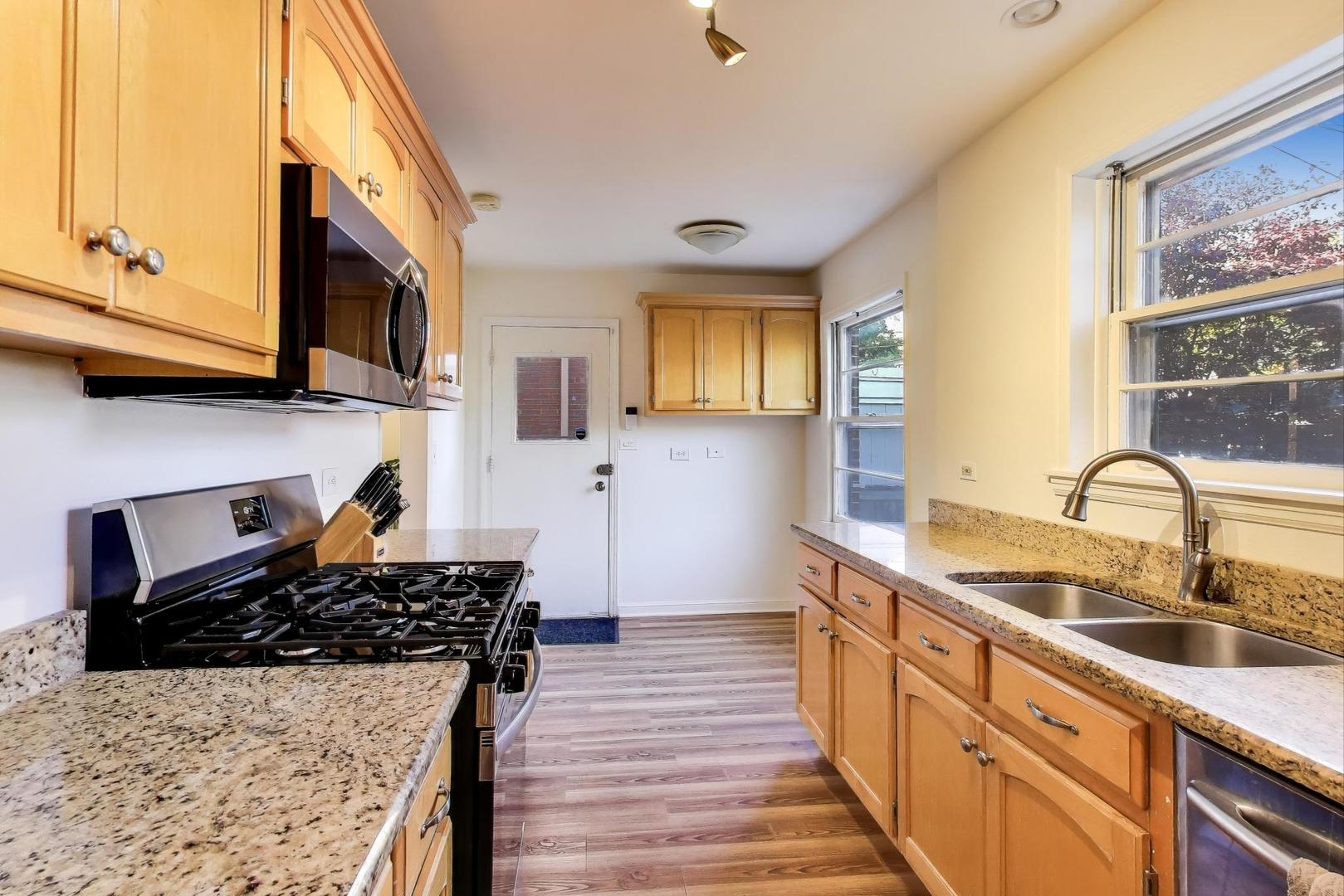 3131 Central Street Evanston, IL 60201 - Photo 8 of 28 a kitchen with stainless steel appliances granite countertop a sink stove and cabinets