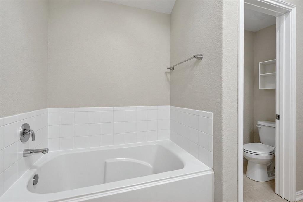 22038 Pheasant Bend Lane Porter, TX 77365 - Photo 16 of 25 a white bath tub sitting next to a toilet