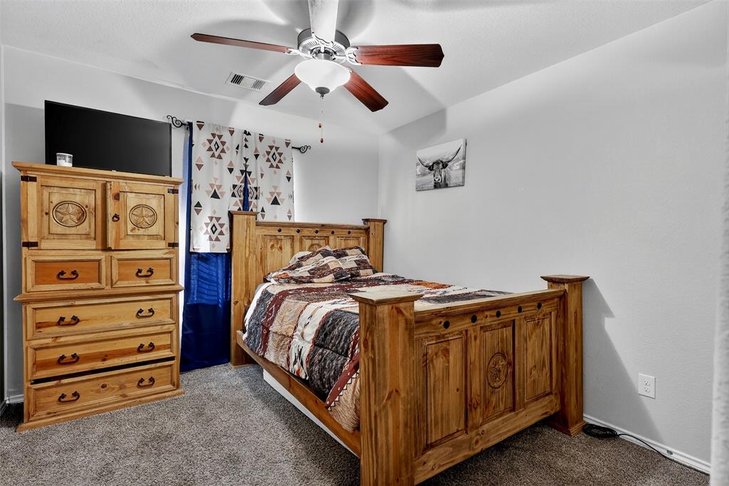 22038 Pheasant Bend Lane Porter, TX 77365 - Photo 17 of 25 a bedroom with a bed and a flat tv screen on the dresser