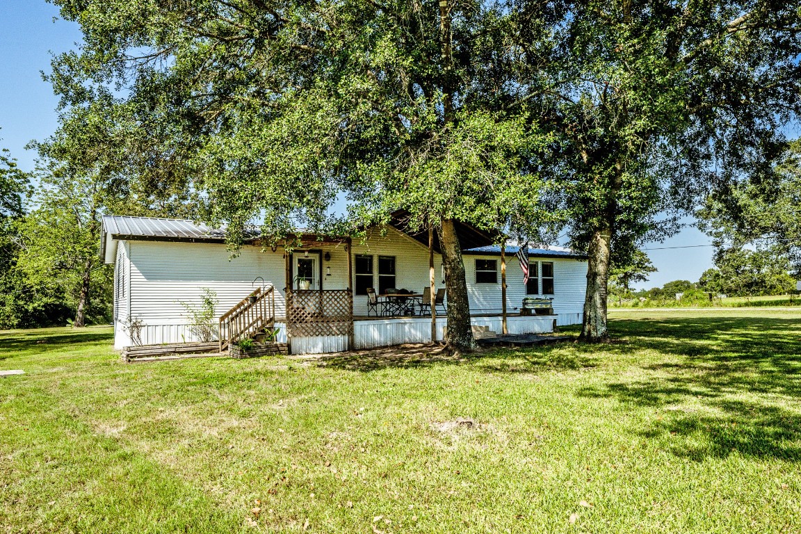 34 Harding Road Huntsville, TX 77340 - Photo 6 of 28 a house that has a big yard large trees and plants in it