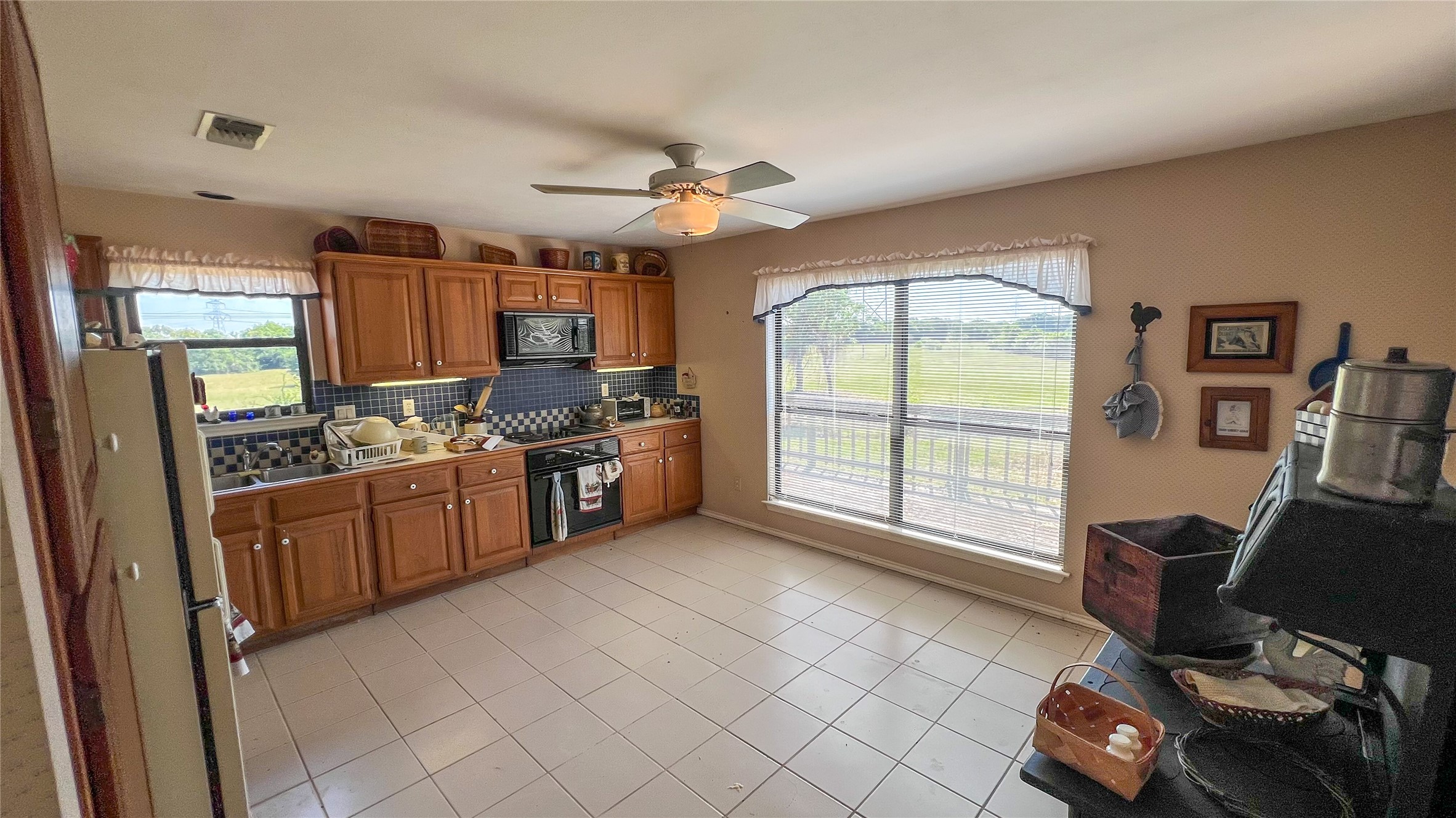 3765 Poteet Road Normangee, TX 77871 - Photo 31 of 37 a kitchen with stainless steel appliances kitchen island granite countertop a stove a sink dishwasher and a view of living room
