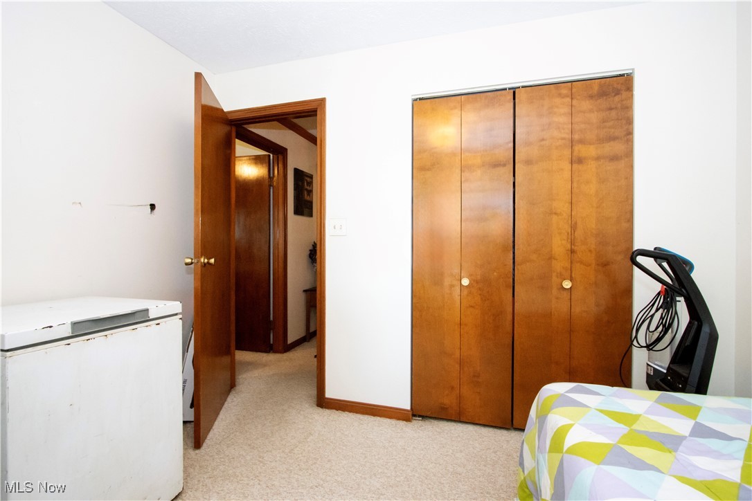 1292 Cinder Road Southeast Carrollton, OH 44615 - Photo 36 of 42 Bedroom with a closet, light carpet, and fridge