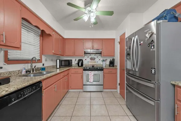 a kitchen with a refrigerator a sink and cabinets