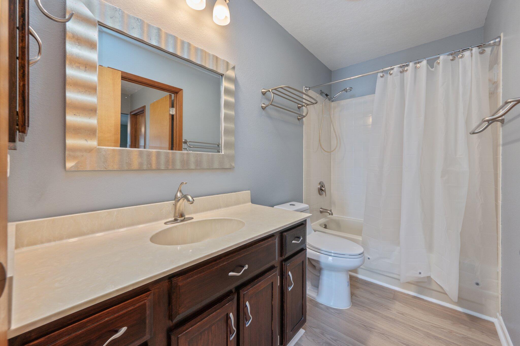 101 Cedar Ridge Way Niceville, FL 32578 - Photo 22 of 33 a bathroom with a sink a toilet a mirror and shower curtain