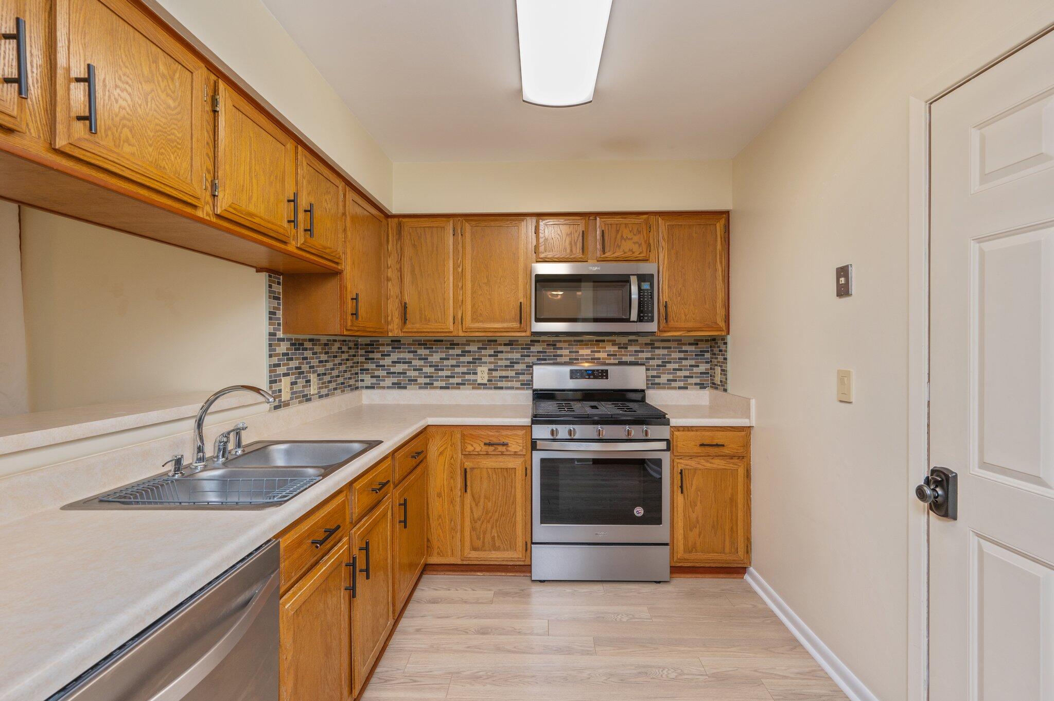 101 Cedar Ridge Way Niceville, FL 32578 - Photo 10 of 33 a kitchen with stainless steel appliances granite countertop a sink stove microwave and refrigerator