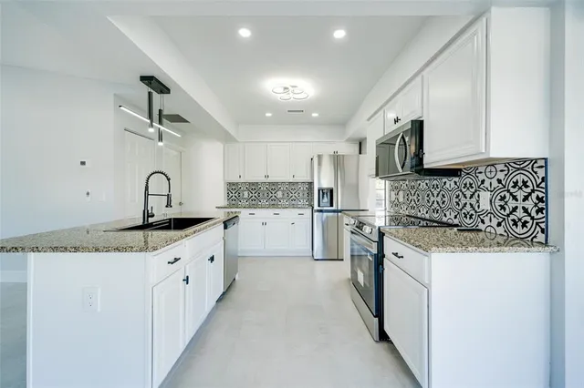 a kitchen with stainless steel appliances granite countertop a sink stove and oven