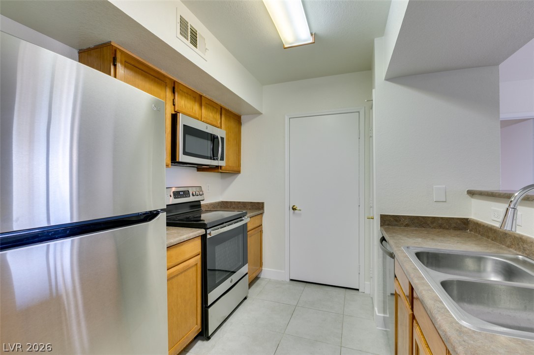 6650 West Warm Springs Road, Unit 2118 Las Vegas, NV 89118 - Photo 13 of 41 A galley kitchen boasts stainless steel appliances and ample counter space.