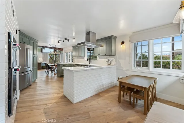 a kitchen with stainless steel appliances a refrigerator and a wooden floor