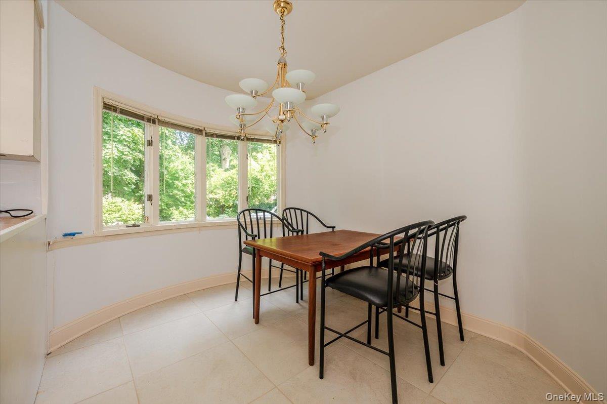 1 Parkside Drive Great Neck, NY 11021 - Photo 12 of 30 Dining area featuring a chandelier and light tile patterned floors