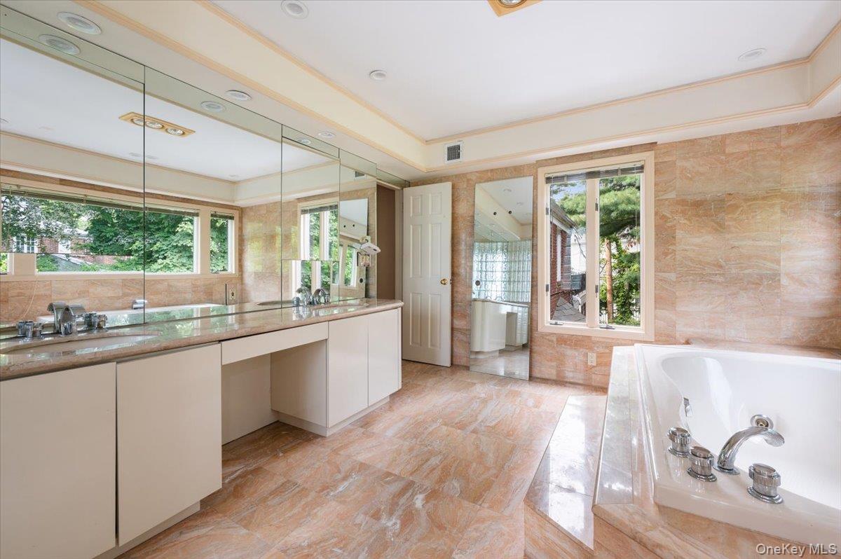 1 Parkside Drive Great Neck, NY 11021 - Photo 16 of 30 Bathroom featuring a whirlpool tub, tile walls, and double vanity