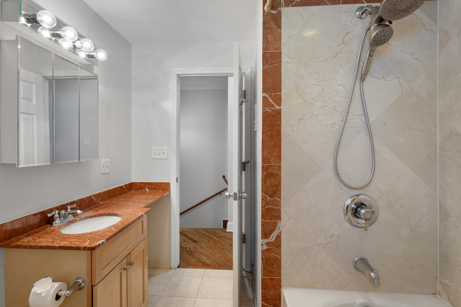 4110 North Keystone Avenue, Unit 1N Chicago, IL 60641 - Photo 7 of 15 a bathroom with a sink a mirror and shower