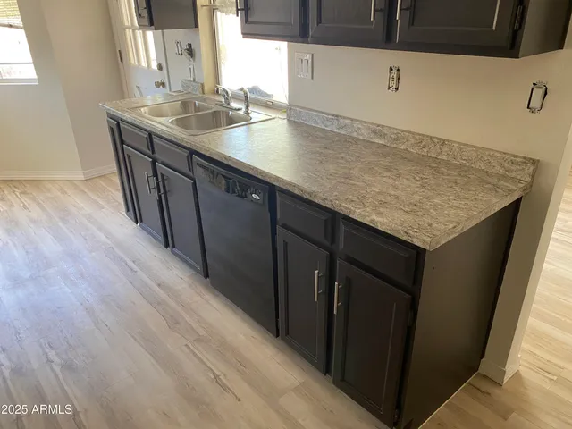 a kitchen with sink cabinets and wooden floor