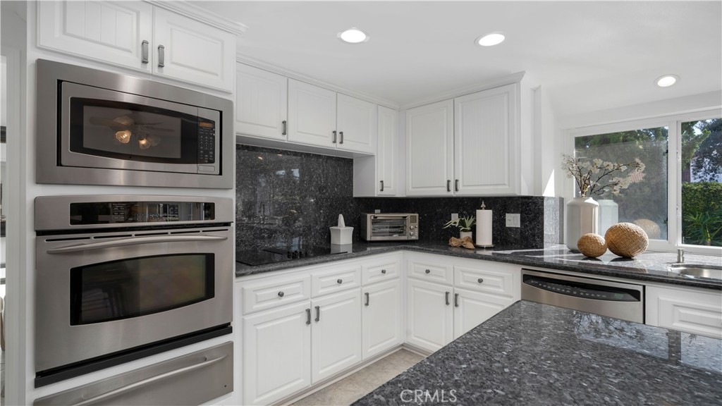 7 Nantucket Irvine, CA 92620 - Photo 16 of 55 a kitchen with granite countertop a stove a microwave and a view of living room