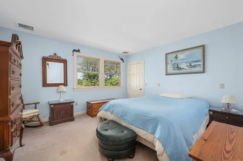 a bedroom with a bed and a lamp on dresser