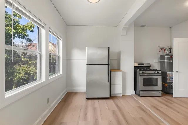 a kitchen with granite countertop a refrigerator and a stove top oven
