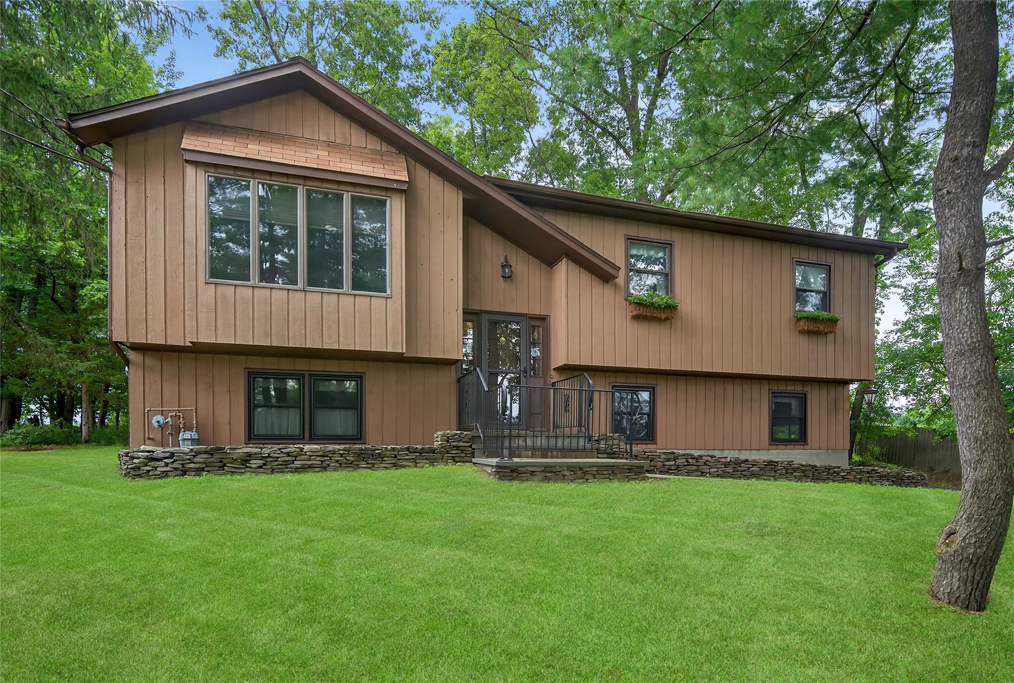 a front view of house with yard and green space