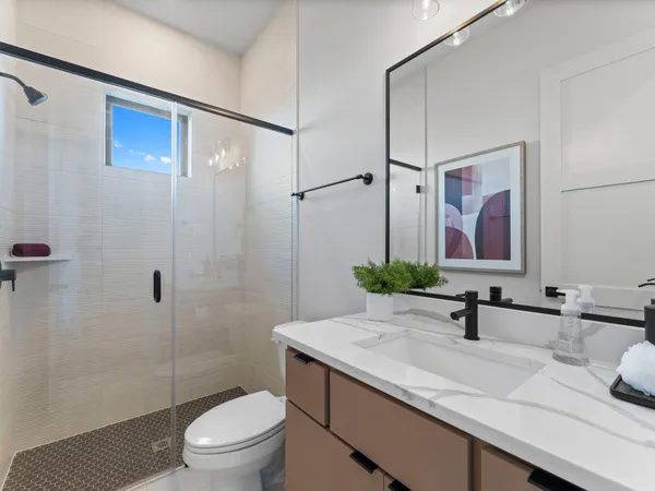 a bathroom with a sink a toilet and shower