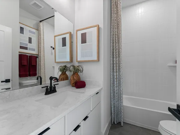 a bathroom with a sink a toilet and shower