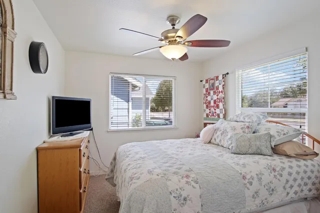 a bedroom with a bed and a flat tv screen on dresser